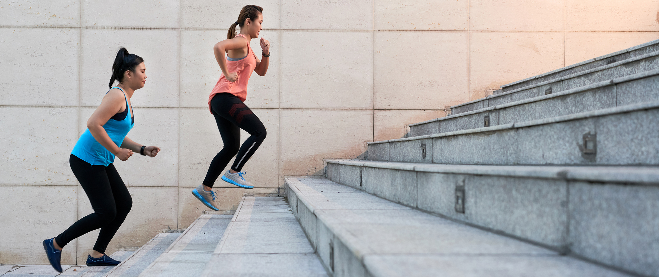 Female friends running up the stairs during morning training