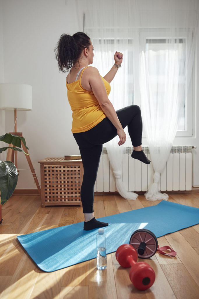 Woman training inside the living room, exercising at home.